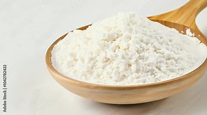 pure GDL odorless white crystalline powder presented wooden spoon illustrating use food additive acidity regulation leavening agent beautifully captured 4K video rotating features