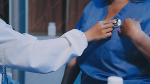 Close up of Female Doctor using stethoscope putting beat heart diagnose with patient in examination room at a hospital, check-up body, Medical and Health Care Concept.