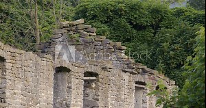 close up of a derelict stone Gable end with windows next to Peakshole water stream in the hope valley, Castleton.
