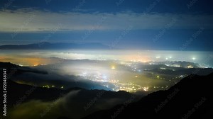 Creating a glazed halo of light from the clouds and the lights of the village. Warm winter mountain scenery in northern Taiwan, Shuangxi Buyanting Pavilion.