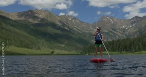 4K Young Woman Paddles Away On Stand Up Paddle Board