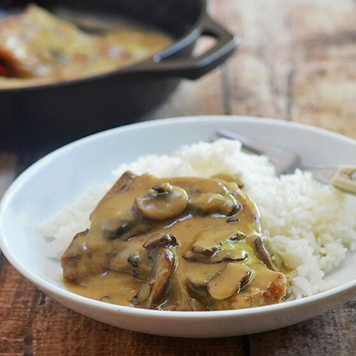 Smothered Pork Chops with mushroom gravy made of from-scratch ingredients and no canned soup. Super-tender pork and flavorful brown gravy perfect with rice, mashed potatoes or noodles. Cooks in one pan and can be made in the oven or slow cooker! https://www.onionringsandthings.com/smothered-pork-chops-mushroom-gravy/ | Kawaling Pinoy Recipe Blog