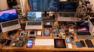 An Impressive Array of Technology: A Workstation Filled with Multiple Laptops, Smartphones, and Circuit Boards Showcasing the Latest in Digital Innovation and Connectivity | Premium Stock Video Footage