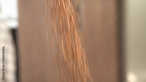 Pouring buckwheat into a storage container in the kitchen close-up, slow motion