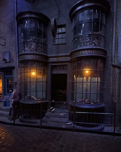 🔥 Incendio 🔥 Visiting during Dark Arts? Watch on as our Death Eaters take Ollivanders by storm. 💀 [Visual description: Two Death Eaters demonstrate casting a spell on Diagon Alley and activate the special effects in the Ollivanders set at the Studio Tour, making it look like the shop has exploded into flames]. | Warner Bros. Studio Tour London
