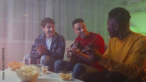 Group of happy multiethnic guys friends playing guitar and singing together, having fun at home in evening, zoom in