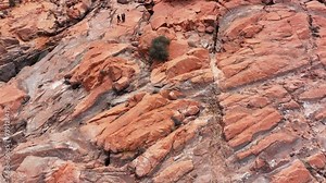 Aerial red rock desert cliff hikers exploring Utah 1. Gunlock State Park of Utah. Red rock sandstone and black volcanic landscape. Overflow from reservoir lake. Natural environment.