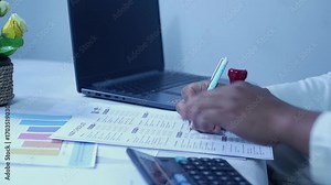 A person checks off a to-do list and a budget list. Checks off all the status checklist boxes and then stamps them. The concept of checking and approving