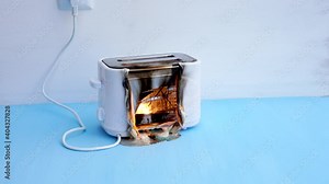 Toaster on fire. Household electrical appliance fire hazard. Overload. Short circuit. Carelessness. Safety in home. Danger home inflammation Insurance concept