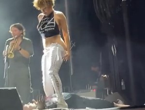 Band apologizes for singer after she pees on fan's face during concert