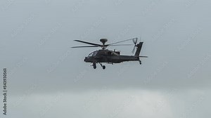 detailed close-up of British army Boeing Apache Attack helicopter gunship (AH-64E AH64E) flying low and banking left, Wilts UK