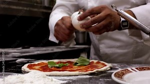 Chef putting mozzarella cheese on a pizza