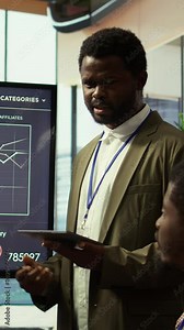 Vertical Video Coworkers engaging in a problem solving meeting at a corporation, using an interactive board to visualize data and develop solutions for complex challenges. Analysis presentation