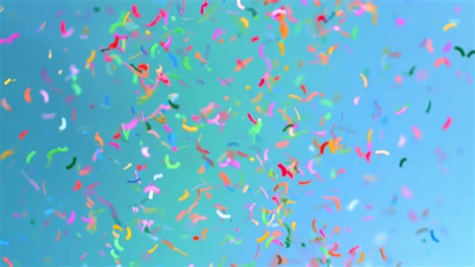 Multicolored confetti falling in slow motion over a blue background - Free Stock Video