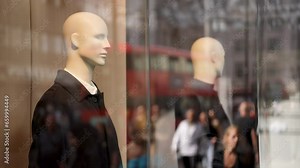 Shop window dummies on Oxford Street. Window display mannequins with busy Oxford Street reflected in the window.