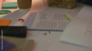 Logo design papers on table, working at night in office and graphic design documents for deadline. Website development meeting, planning brand marketing of homepage and creative collaboration studio