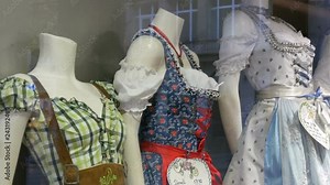 Beautiful various women's national Bavarian costumes dirndl on shop window