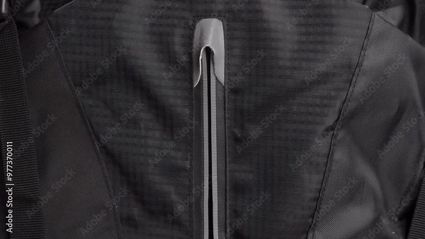 Man's hands unzip and zip up a backpack. Zipper or fastener unzipping close-up