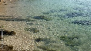 Simmering reflexions of surface water in a small pool by the sea shore.