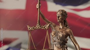 Lady Justice statue with UK flag as background. United Kingdom Law and justice concept. Legal system.