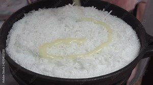 Tapioca from the storage of the cassava plant (also known as manioc or yuca). Adding condensed milk with grated coconut to Beiju (or Biju) at brazilian open-air marketplace, a free fair farmer Market