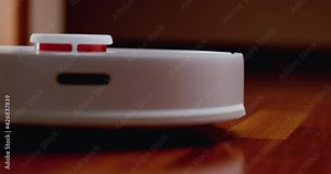 Smart Robot Vacuum Cleaner with lidar on wood floor. Robot vacuum cleaner performs automatic cleaning of the apartment. 4K slow motion 100 fps, ProRes 422, 10 bit