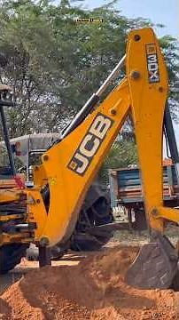 Backhoe loader loading mud in tractor