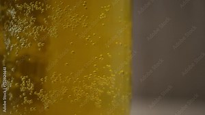 Blonde beer close up background. Bubbles of air carbon dioxide in beer float to the top. Glowing light golden ale with effervescence in a full frame background texture for for beer, brewery