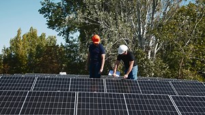 Download Connection and installation of solar panels. Workers attach solar panels. Technicians install solar panels on a metal stand. Workers install photovoltaic solar panels on the roof of a house for free