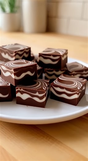 3-Ingredient Marshmallow Swirl Fudge Rich Chocolate Marshmallow Swirl Fudge Squares Ingredients: Semi sweet chocolate chips Sweetened condensed milk Marshmallow fluff Directions: Melt the semi-sweet chocolate chips with the sweetened condensed milk in a heatproof bowl, stirring until thick, smooth, and fully combined. Drop spoonfuls of marshmallow fluff onto the warm chocolate mixture and gently swirl with a knife to create a marbled pattern. Transfer the mixture into a parchment-lined square pa