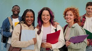 Group portrait of smiling University students standing on university blue wall, hispanic girl together with college classmate friends