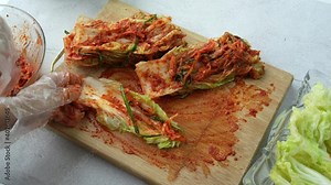 Making Korean pickles, kimchi. Woman hand mixing vegetables , kimchi sauce and seasoning ingredient to make Kimchi Korean traditional food. Stock Video
