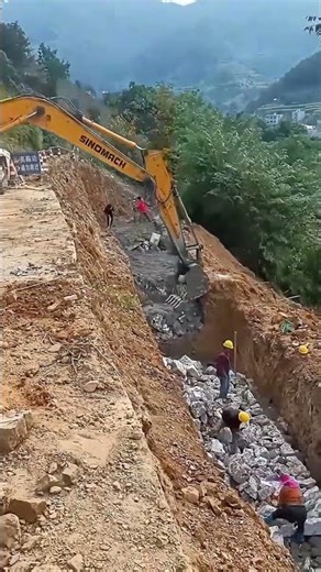The process of excavators assisting workers in building slope protection
