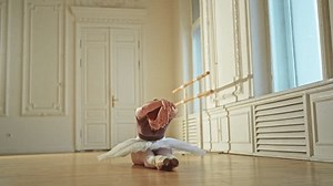Young ballerina in tutu skirt stretching practicing ballet positions dancing in dance class. Young classical dancer woman in dance studio. Ballet class training Ballet school concept