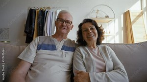 Elderly couple talks on video call via webcam with friends smiling. Senior man and woman distract on grandchildren coming to hug from POV to third party