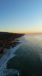 Magoito Beach and Cliffs at Sunset during Low Tide. Atlantic Ocean, Portugal. Golden Hour. Aerial View. Moving Backwards. Vertical