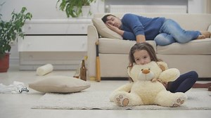 Tochter spielt während betrunkener Vater auf dem Sofa hinter in 4k Video schlafen.
