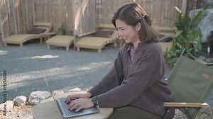Young happy smiling Asain woman in cafe working video call facetime type project working on her laptop notebook personal computer, Female begins typing say hello on laptop