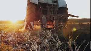 Rear view of an old gray tractor with a harrow