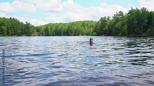 An active woman enjoying wild swimming as part of a healthy outdoor lifestyle.