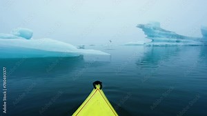Winter Kayaking in Jökulsárlón the Glacial Lake in Iceland with Iceberg in a Yellow Kayak. Jokulsarlon Icebergs