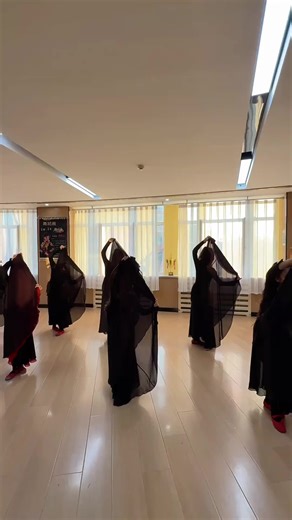 A group of dancers in black ethnic costumes are dancing joyfully in the studio!Their movements are neat and rhythmic, showing the rich charm of ethnic dance