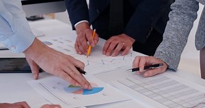 Une réunion de gestion de projet et de discuter des délais et des livrables, l'analyse ensemble sur les objectifs de croissance de l'entreprise et les marges bénéficiaires brutes des rapports d'investissement aux clients à la table de bureau.