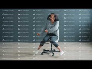 Happy African American woman spinning sitting on office chair dancing having fun