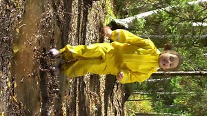 Little girl in a yellow rubber suit is jumping in a puddle. Stock Video