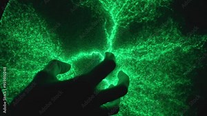 Hand touch plasma ball, creating vibrant green lightning patterns. Static electricity model on science exhibit