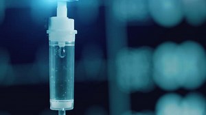 Medical IV saline drip with ECG monitor on the background. Healthcare technology for patient care and emergency treatment. Modern hospital equipment for recovery, surgery and intravenous therapy