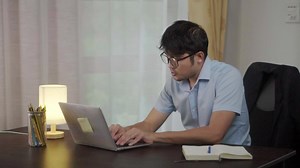 Download Asian man with neck pain or office syndrome at reserving a laptop at your desk at home. for free