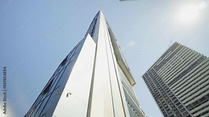 View of skyscrapers at low angle. Look into future. View from below of modern skyscrapers in business district. Business concept of success industry or real estate investment. Camera rotation.