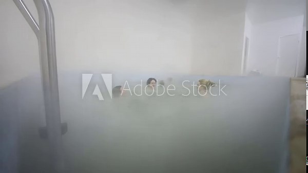 Heads of women and girls in water of natural curative hot spring and man going